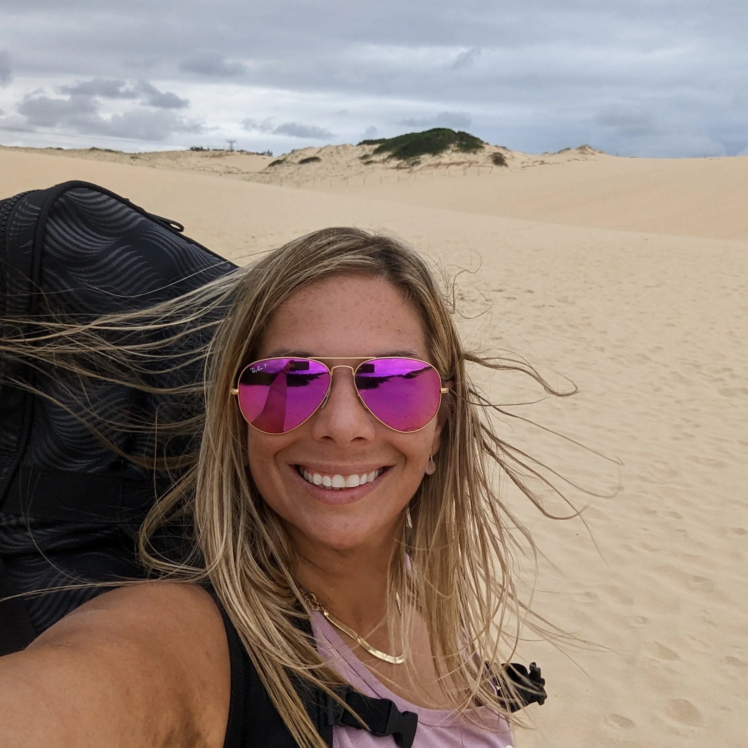 a woman hiking with her paddle board while travelling