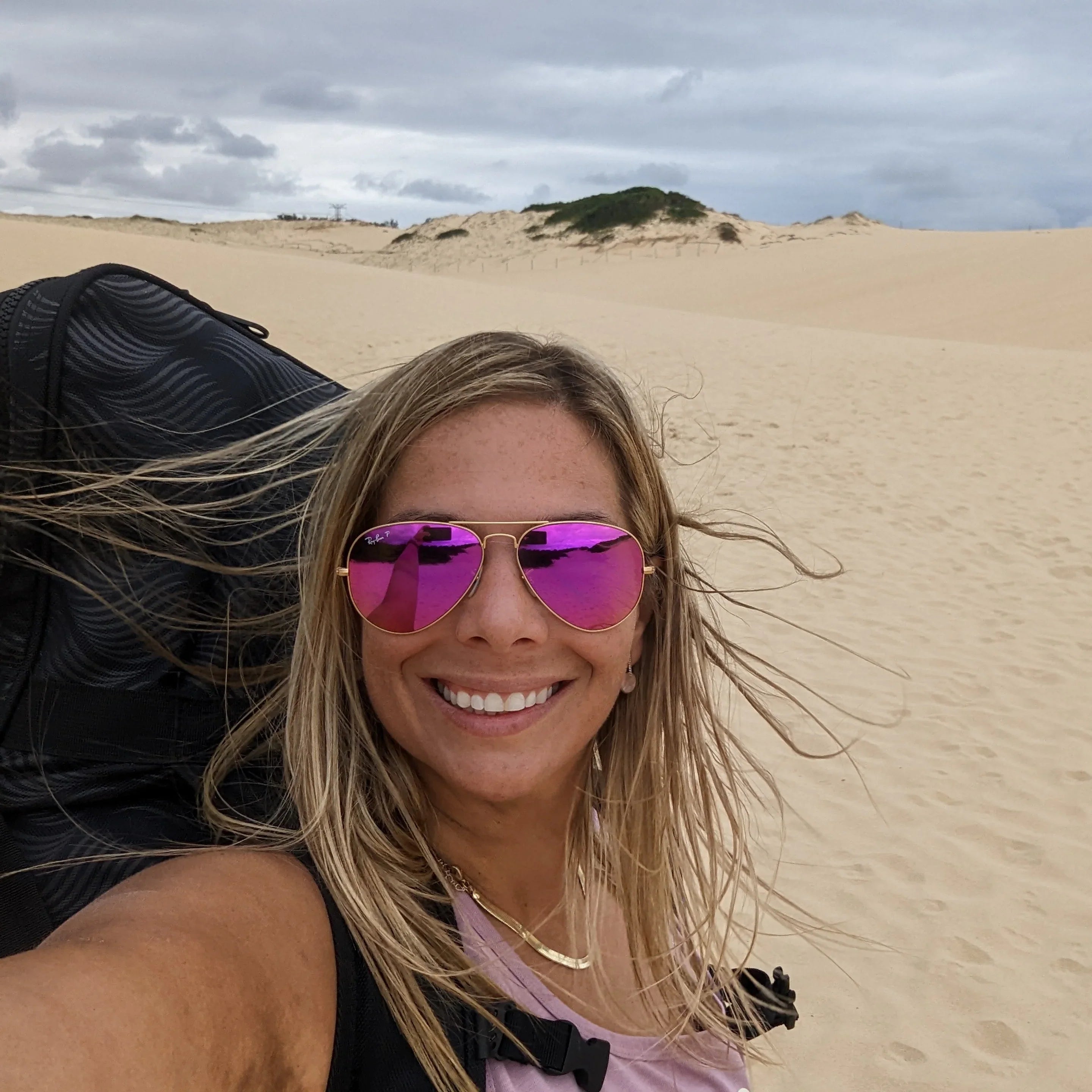 a woman hiking with her paddle board while travelling